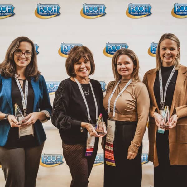 Four women holding awards at PCOH event.