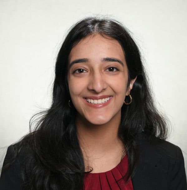Smiling woman in black blazer and red top